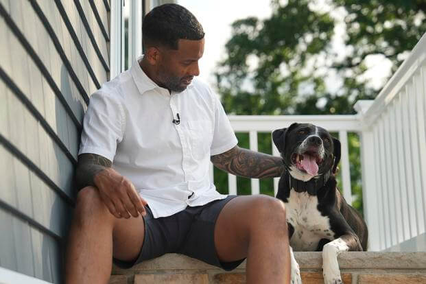 Dave Crenshaw poses for a photo with his service dog, Doc, in front of his home in Kearny, N.J.