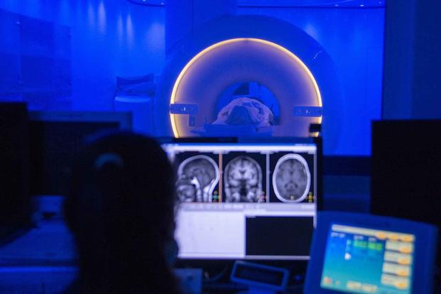 An U.S. Navy MRI technologist conducts an MRI scan of a patient's brain