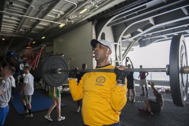 Chief logistics specialist Larry McIntosh, assigned to the supply department aboard the aircraft carrier USS Harry S. Truman (CVN 75), prepares to execute an overhead press during a functional fitness class. 