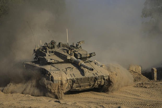 An Israeli soldier moves on the top of a tank near the Israeli-Gaza border.