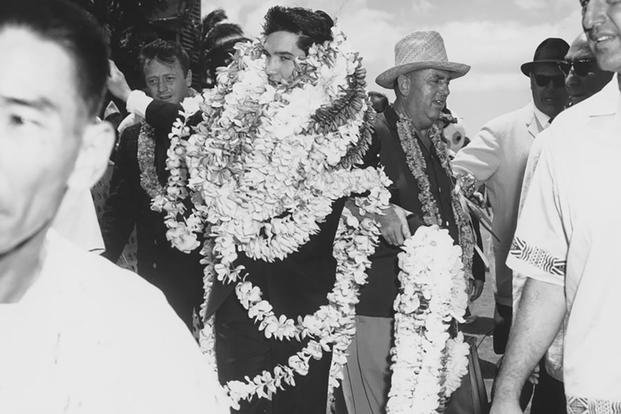 Several leis hang around the neck of Elvis Presley after his arrival on March 25, 1961, for a concert to benefit the USS Arizona Memorial Fund. 