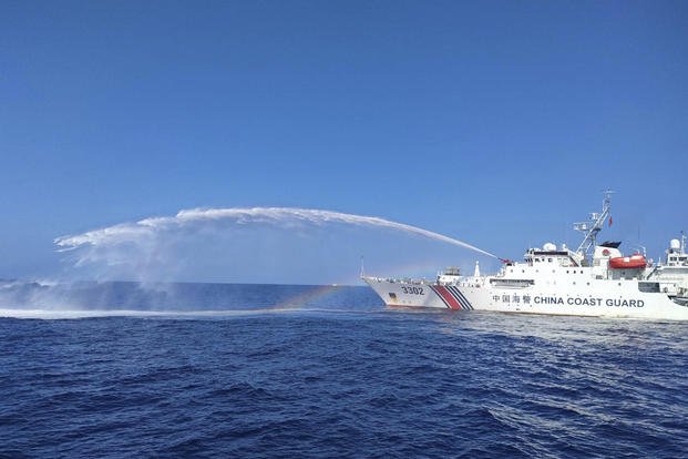 Chinese Coast Guard ship, right, uses its water cannons on a Philippine Bureau of Fisheries and Aquatic Resources (BFAR) vessel