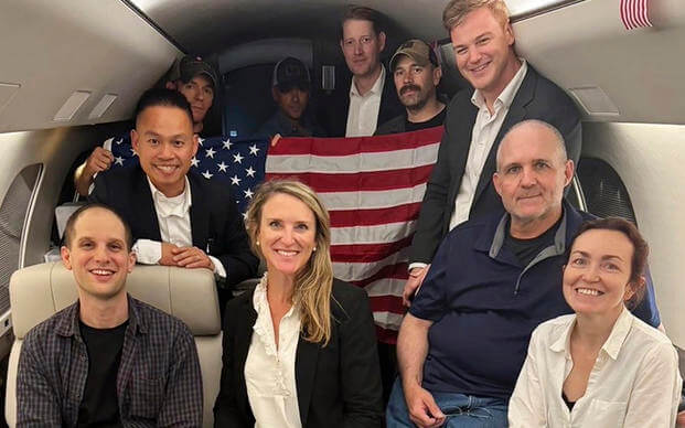 This image released by the White House shows Evan Gershkovich, left, Alsu Kurmasheva, right, and Paul Whelan, second from right, and others aboard a plane, Thursday, Aug. 1, 2024, following their release from Russian captivity. 