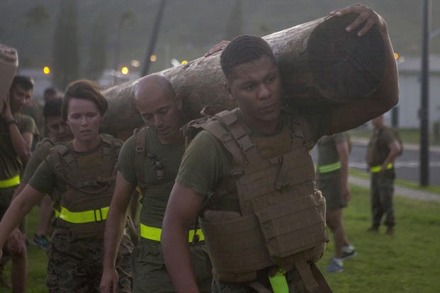 Lance Cpl. Creighton Crenshaw, a pay clerk with Headquarters Battalion, Marine Corps Base Hawaii, carries a log during a battalion physical training session, MCBH.