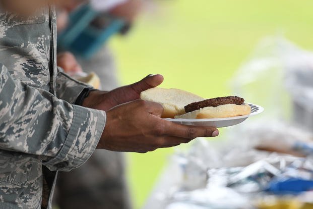 U.S. Air Force Staff Sgt. Tony Galloway, 81st Diagnostic and Therapeutics Squadron radiology technician, holds a plate of food during the Air Force Assistance Fund burger burn at the Crotwell Track on Keesler Air Force Base, Mississippi.