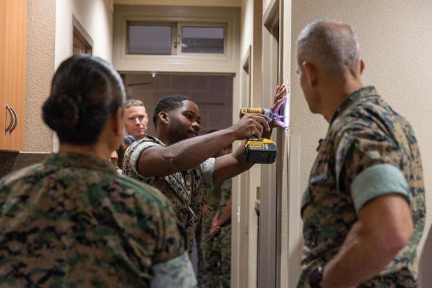 U.S. Marines with Headquarters and Service Battalion, 1st Marine Logistics Group, show Brig. Gen. Andrew M. Niebel, the commanding general of 1st MLG, how they patch holes in the barracks during Operation Clean Sweep at Camp Pendleton, California.