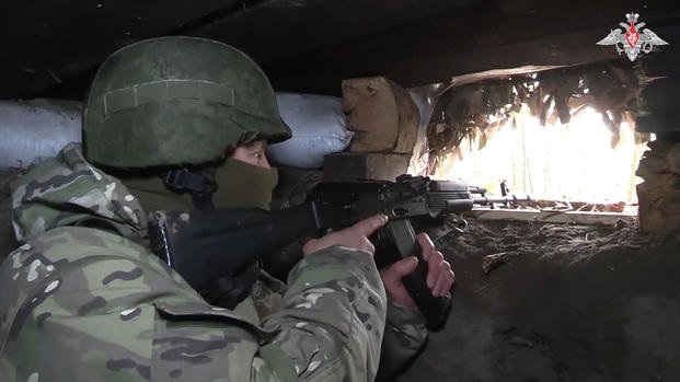 Russian soldier aims from a bunker in the Russian - Ukrainian border area in the Kursk region