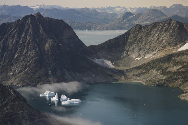 Icebergs are seen through a window of an airplane carrying NASA scientists as they fly on a mission to track melting ice in eastern Greenland.