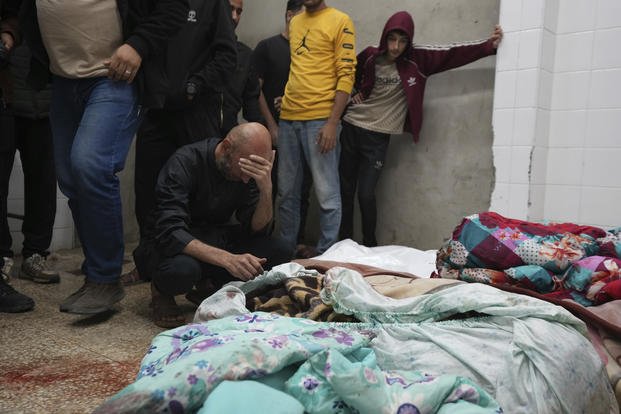 Palestinians mourn over relatives killed in an Israeli bombardment in Nuseirat, central Gaza