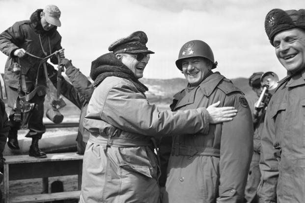 A laughing Gen. Douglas MacArthur pats the shoulder of Maj. Gen. William Hoge, new 9th Corps commander, as Lt. Gen. Matthew Ridgway, right, 8th Army commander, laughs during the supreme commander’s 12th visit to the Korean battlefield on March 7,1951. 