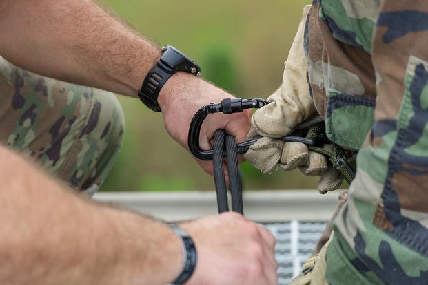 An instructor adjusts safety equipment for a Reserve Officer Training Corps cadet.