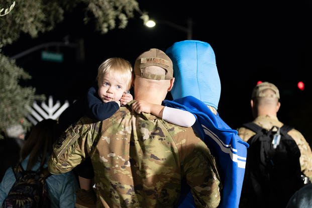 Maj. Andrew Wagner, 9th Air Refueling Squadron flight doctor, holds his son, Everett, left and daughter, Emerson, right, while watching the Travis Air Force Base menorah lighting ceremony at Travis AFB, California.