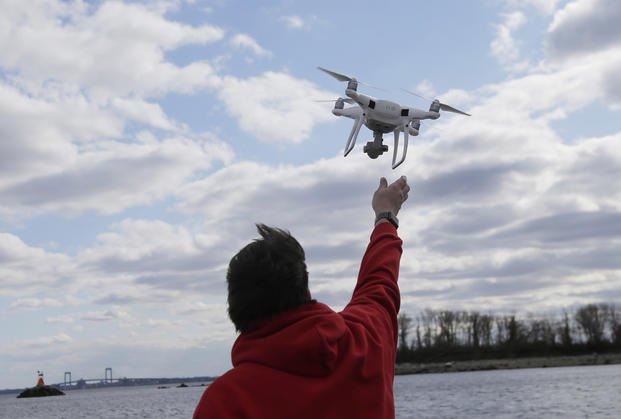 Drone operator helps to retrieve a drone over Hart Island in New York