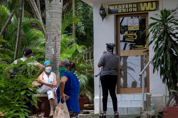 People stand outside a Western Union in the Vedado neighborhood of Havana, Cuba. 