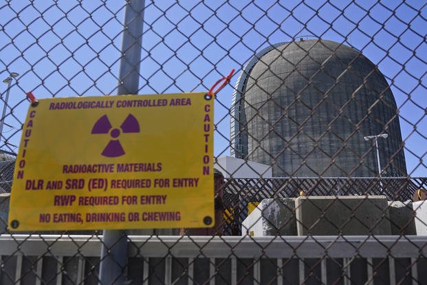 A sign on a fence warns of radioactive materials at a containment building housing a nuclear reactor at the Indian Point nuclear power plant in Buchanan, N.Y.