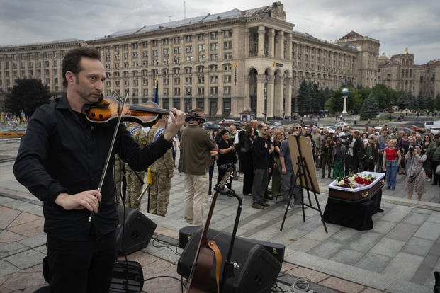 A musician plays the violin during the funeral ceremony for volunteer servicewoman, well-known stylist Shura Riazantseva
