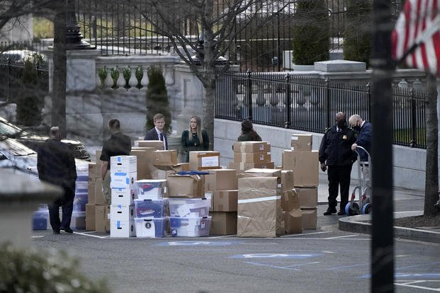 People wait for a moving van after boxes were moved out of the Eisenhower Executive Office building