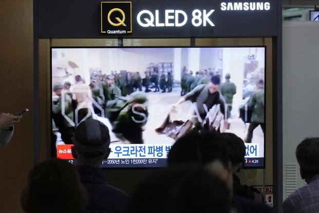soldiers believed to be from North Korea standing in line to receive supplies from Russia