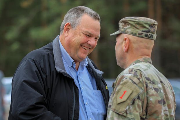 U.S. Army Col. Richard J. Ikena Jr., commander of the 1st Infantry Division Artillery (DIVARTY), greets Jon Tester, a Montana U.S. senator, during a congressional delegation visit at Pabradė Training Area, Lithuania.