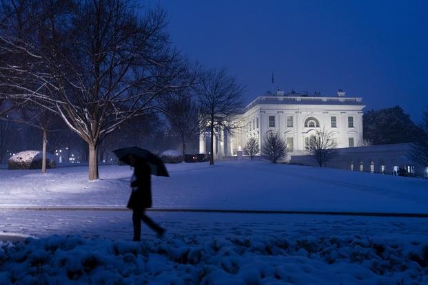 The White House is seen as the snow falls