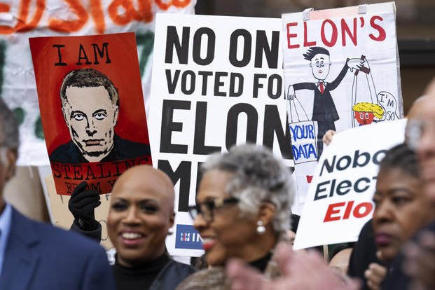 People hold signs in support of the Consumer Financial Protection Bureau