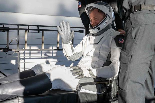 NASA astronaut Col. Nick Hague is helped out of a SpaceX Dragon spacecraft 