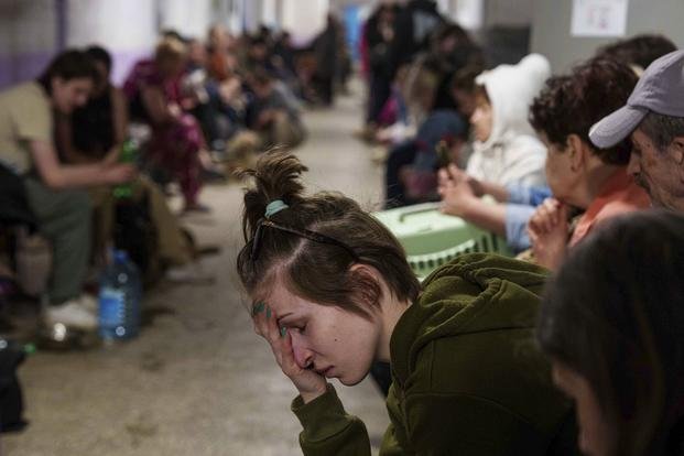 A woman sits in a school basement being used as a shelter after a Russian airstrike