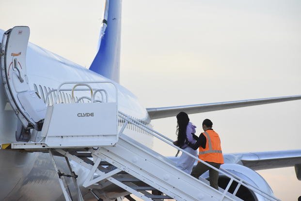 Venezuelans board a plane.