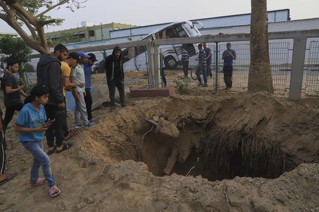 Palestinians inspect the site of an Israeli army airstrike on the European hospital in Khan Younis, Gaza Strip