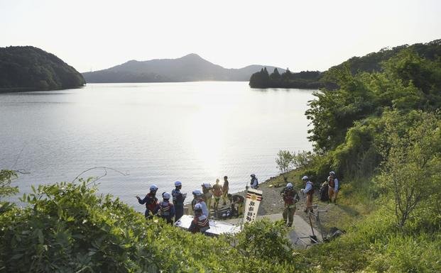 Firefighters gather for a search operation as a Japanese air force plane crashed after taking off for a training flight