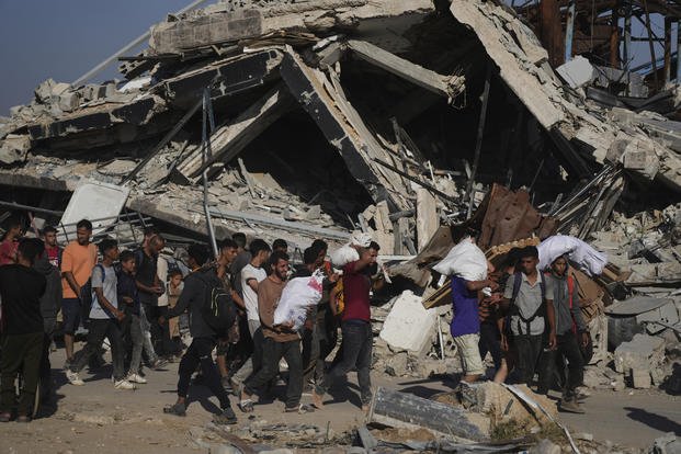Palestinians carry humanitarian aid packages distributed by the Gaza Humanitarian Foundation