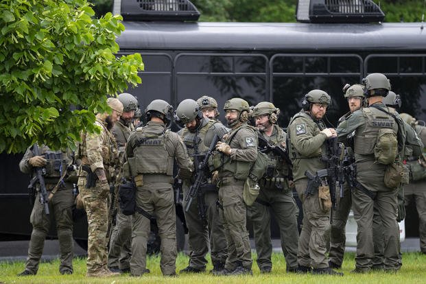 Law enforcement officers stage less than a mile from a shooting in Brooklyn Park, Minnesota.