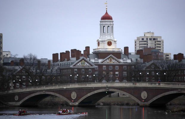 Rowers paddle down the Charles River near the campus of Harvard University in Cambridge, Mass.