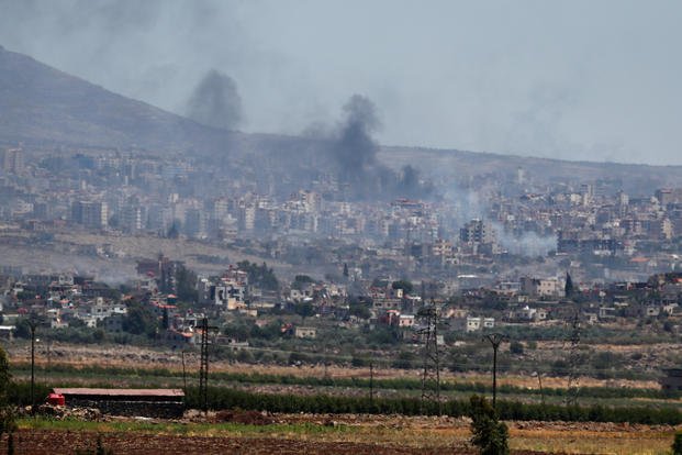 Smoke rises from clashes between Syrian government forces and Druze militias in Sweida city, southern Syria.