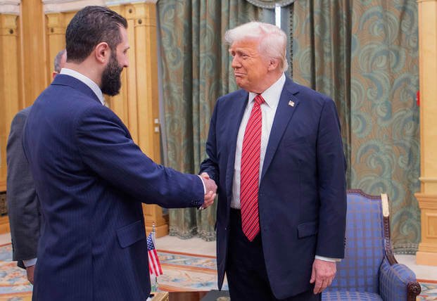 President Donald Trump, right, shakes hands with Syria's interim President Ahmad al-Sharaa