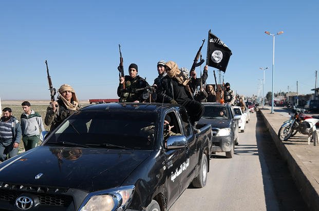 Islamic State militants drive in a convoy through Tel Abyad, northeast Syria
