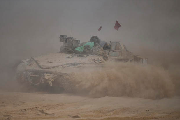 Israeli soldiers move on armored personnel carriers (APC) near the Israeli-Gaza border, in southern Israel