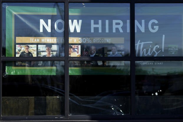A hiring sign is displayed at a grocery store