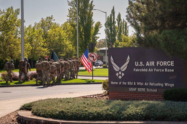 U.S. Air Force Airmen with the 66th Training Squadron’s Pre-Team 26-02 carry the American and POW/MIA flags during the annual POW/MIA memorial ruck march through Fairchild Air Force Base’s main gate during a memorial ruck march