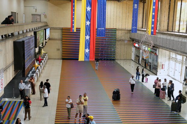 Travelers wait in the main hall of the Simon Bolivar Maiquetia International Airport in Venezuela.