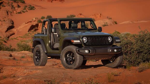 A front three-quarter shot of an army green 2024 Jeep Wrangler posing in a desert