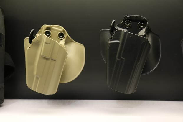 Safariland's new wide-body version of its 578 Pro-Fit holster, shown at right in black, on Jan. 19, 2016, at SHOW Show in Las Vegas. (Photo by Brendan McGarry/Military.com)