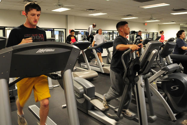 Airmen work out on cardio machines. 