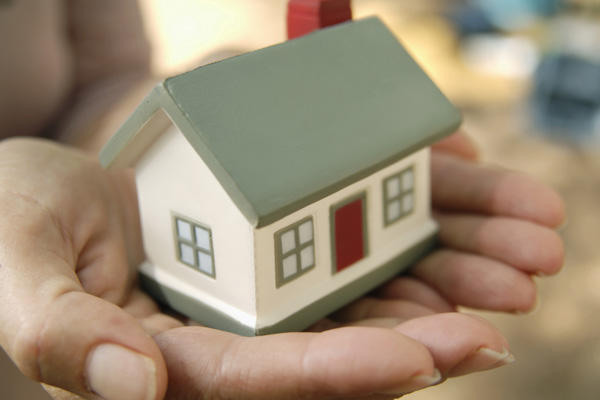 Hands holding a miniature house