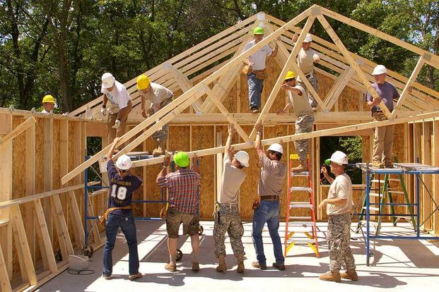 Soldiers help build a house
