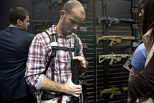 Will Michael of Homer, La., examines a Bushmaster M4 A3 Carbine 300 AAC Blackout rifle at the Bushmaster exhibit during the Shooting Hunting Outdoor Tradeshow, Tuesday, Jan. 15, 2013, in Las Vegas. 