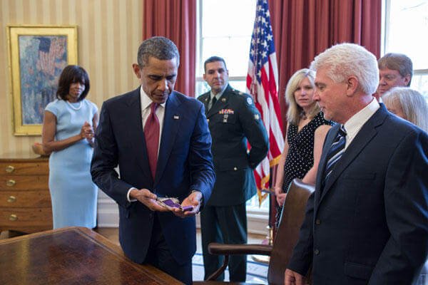 President Barack Obama holds Chaplain (Captain) Emil Kapaun's Easter stole in the Oval Office during a greet with Kapaun's family in the Oval Office, April 11, 2013. (Official White House Photo by Pete Souza)