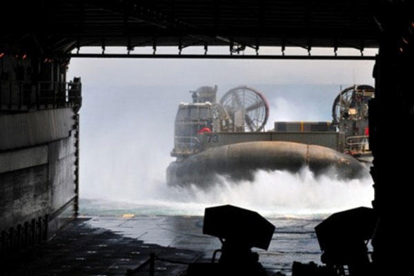 A landing craft, air cushioned, approaches the well deck of amphibious dock landing ship USS Pearl Harbor (LSD 52).