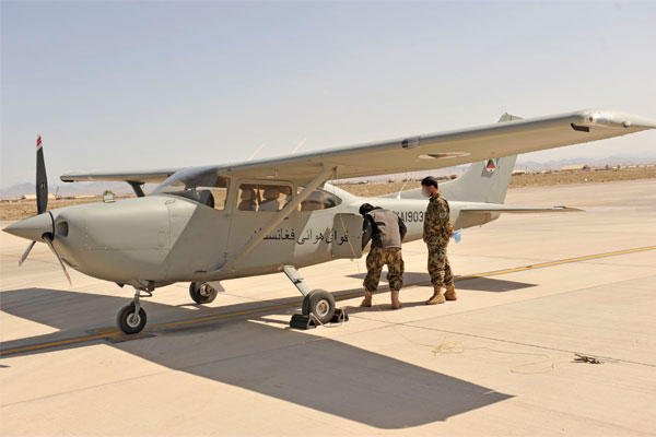 Two Afghan pilot students do a preflight check on a Cessna 182 at Shindand Airfield, Afghanistan, March 9, 2014.