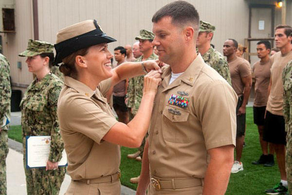 Diana Flowers pins new collar devices on her husband, Michael Flowers, during a frocking ceremony June 30, 2014, at Naval Base Coronado. Both were frocked to senior chief. (US Navy photo by Paul Coover)